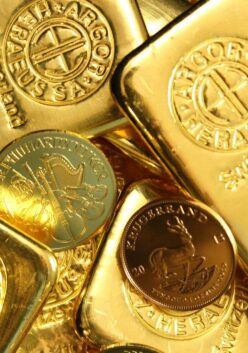 A collection of gold bars and coins with stamped markings and emblems