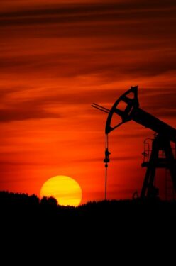 oil pump jack silhouette against red sunset